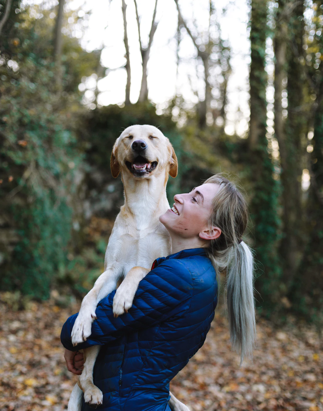Köpeğini kucaklayıp gülen bir kadın